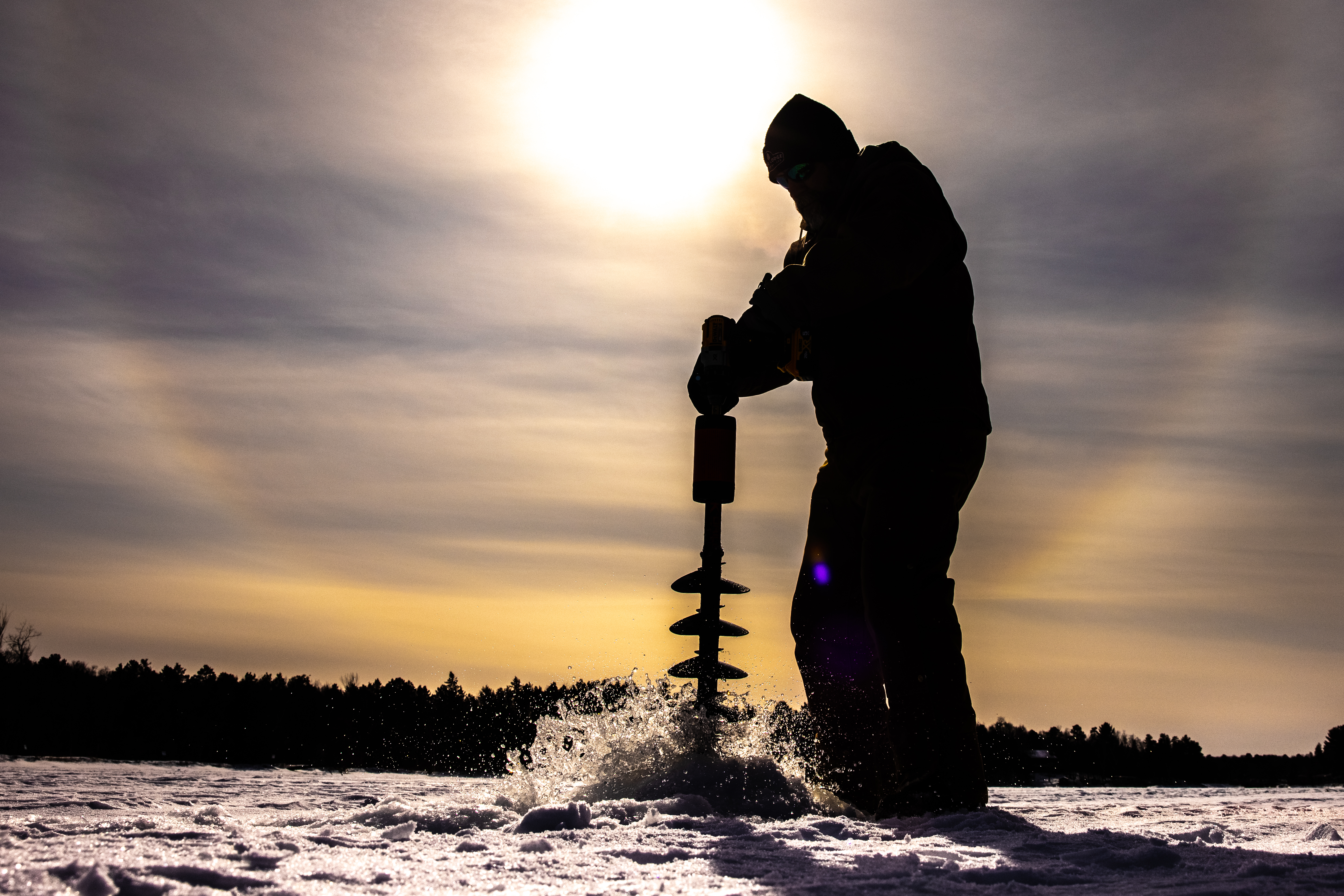 Drilling a hole for ice fishing on Whitefish Lake