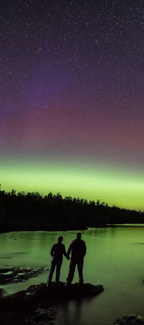 A couple watches the northern lights at Gooseberry Falls State Park