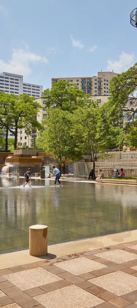Kids splash in the water at Peavey Plaza in downtown Minneapolis