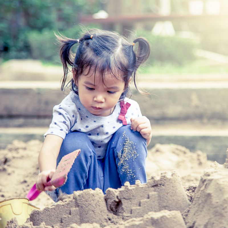 Girl playing in sandbox at the Minnesota Zoo Tropical Beach Party