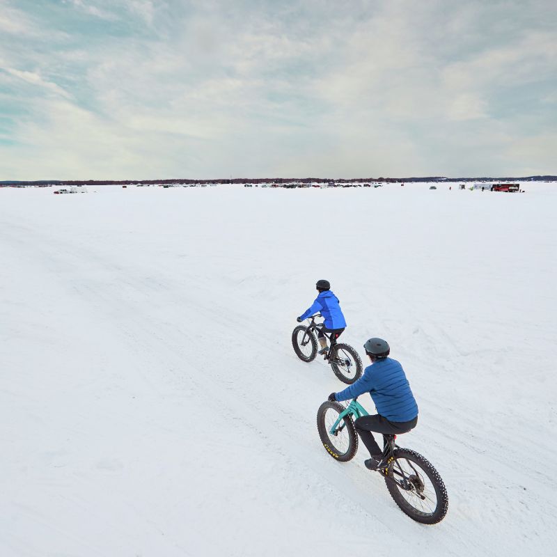 Two people fat biking on a frozen Minnesota lake