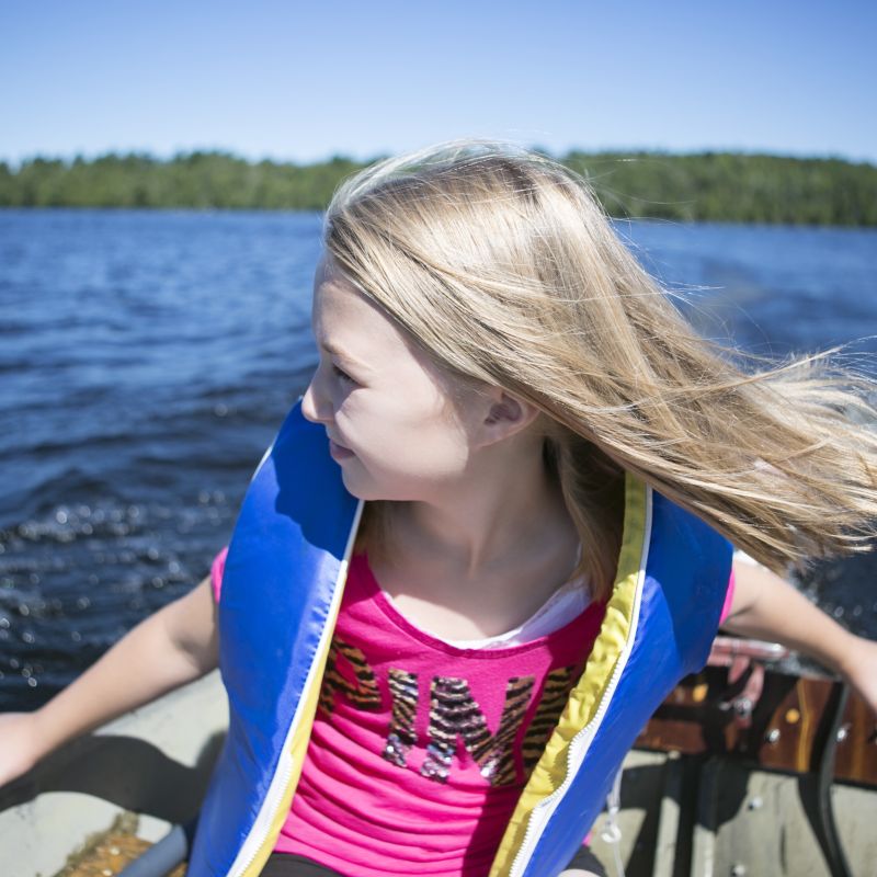 A girl learns how to drive a boat on Lake Vermilion